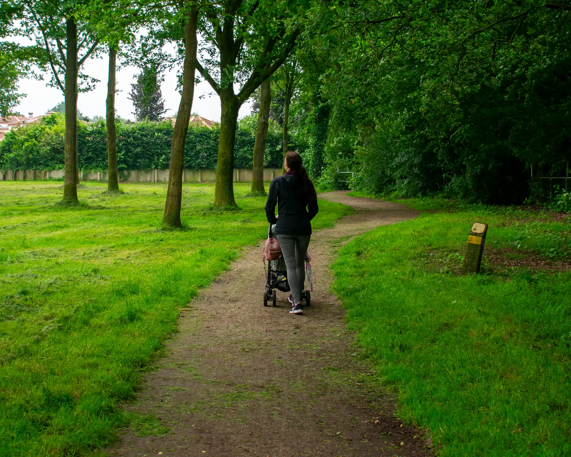 Frau mit Kinderwagen beim Spaziergang